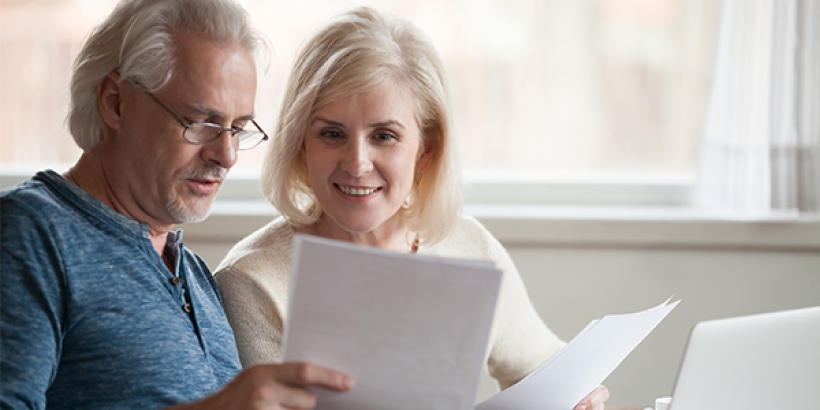 Couple looking at papers and laptop
